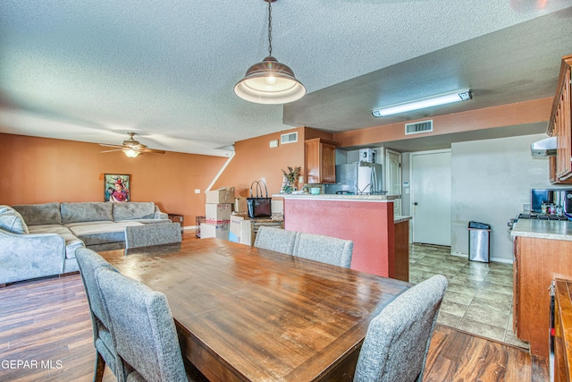 dining space featuring dark hardwood / wood-style flooring, a textured ceiling, and ceiling fan