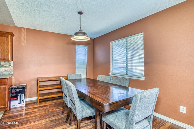 dining space with dark hardwood / wood-style flooring and a textured ceiling