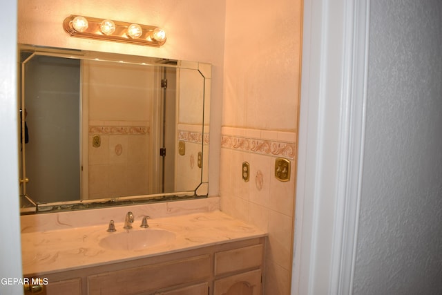 bathroom with vanity and tile walls