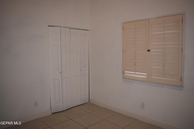 unfurnished bedroom with a closet and light tile patterned floors