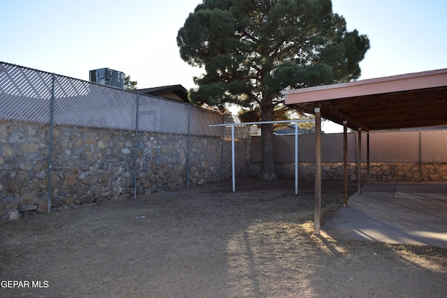 view of yard featuring a carport and central AC