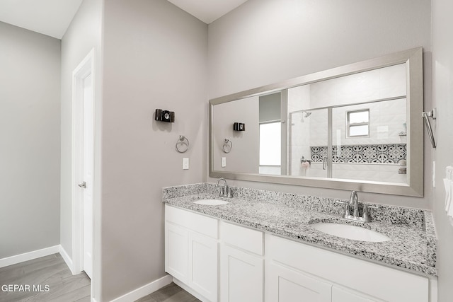 bathroom featuring a shower with door and vanity