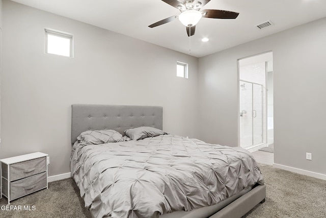 carpeted bedroom with multiple windows, ceiling fan, and ensuite bath