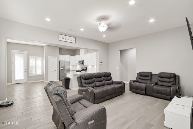 living room featuring ceiling fan and light hardwood / wood-style floors