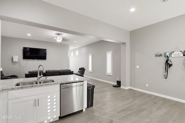 kitchen featuring white cabinetry, sink, stainless steel dishwasher, light stone counters, and light hardwood / wood-style flooring