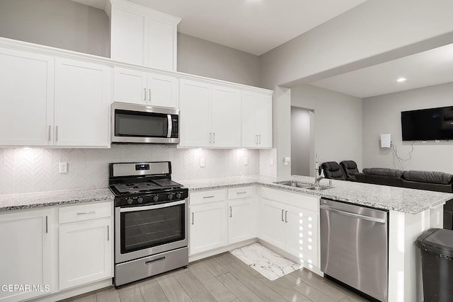 kitchen featuring white cabinetry, appliances with stainless steel finishes, and kitchen peninsula