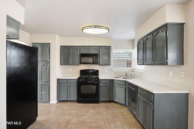 kitchen featuring sink, gray cabinetry, light tile patterned floors, and black appliances