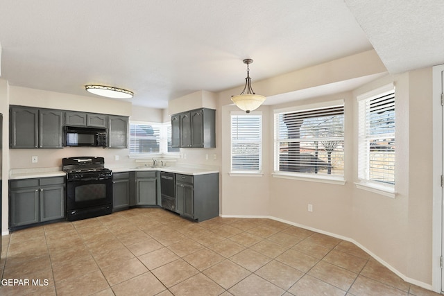 kitchen with sink, pendant lighting, light tile patterned floors, and black appliances