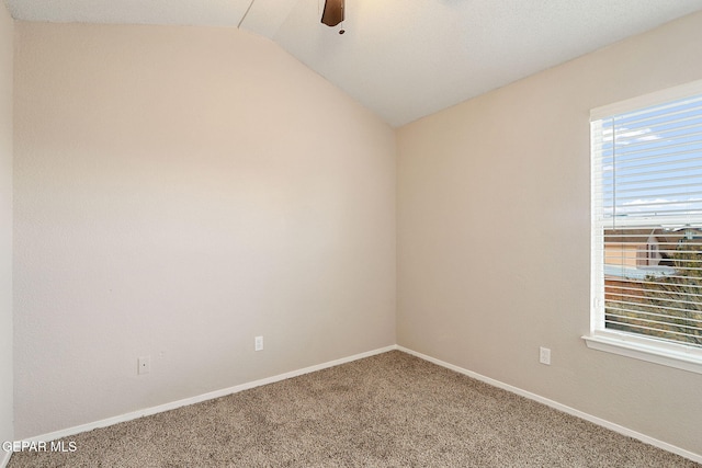 empty room featuring ceiling fan, lofted ceiling, and carpet