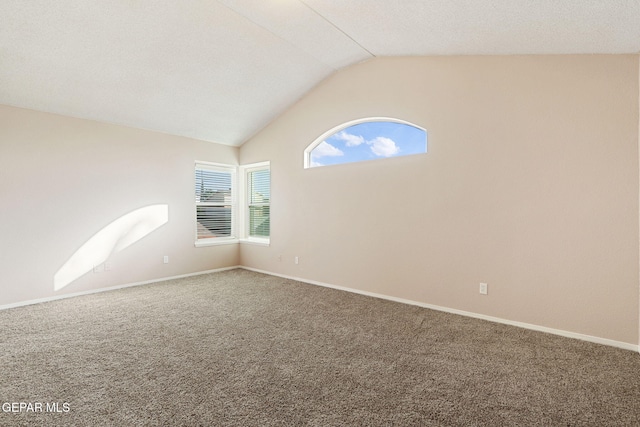 carpeted spare room with lofted ceiling