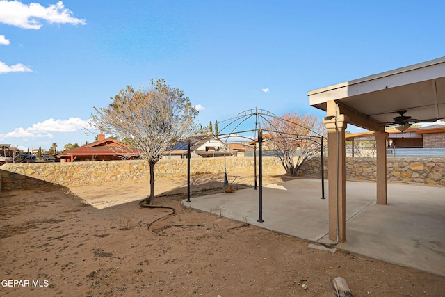 view of yard with ceiling fan and a patio