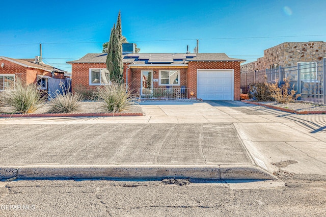 ranch-style home with a garage and solar panels