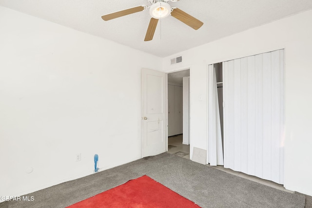 unfurnished bedroom featuring ceiling fan, a closet, and carpet