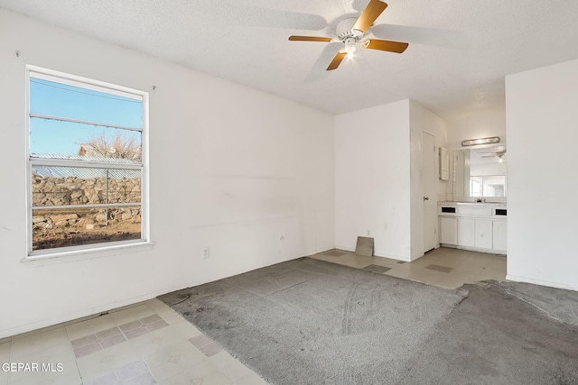 interior space with ceiling fan and a textured ceiling