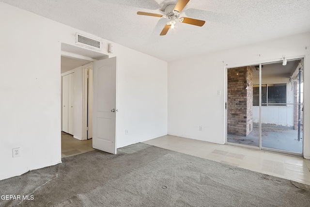 unfurnished room with ceiling fan, carpet flooring, and a textured ceiling