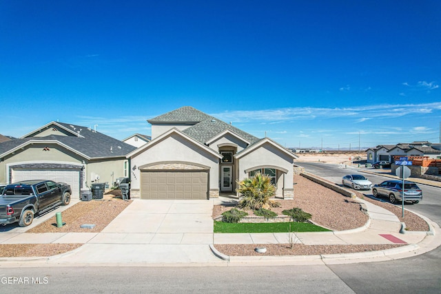 view of front of house featuring a garage, roof with shingles, concrete driveway, and stucco siding