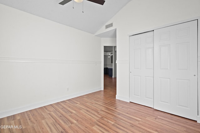 unfurnished bedroom featuring ceiling fan, high vaulted ceiling, light hardwood / wood-style floors, and a closet