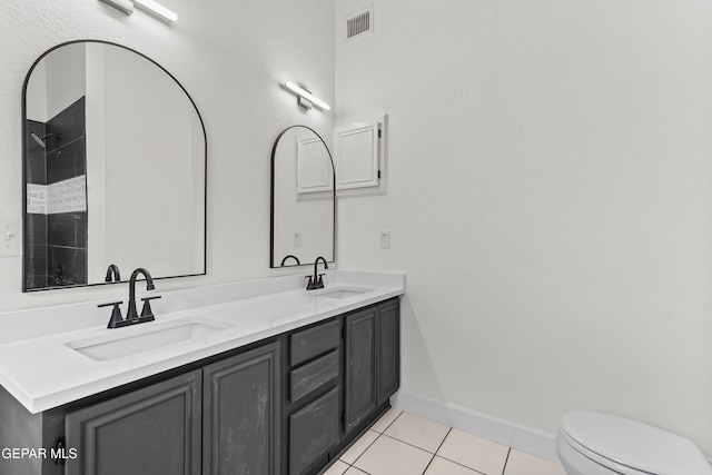 bathroom with vanity, toilet, tile patterned flooring, and a shower