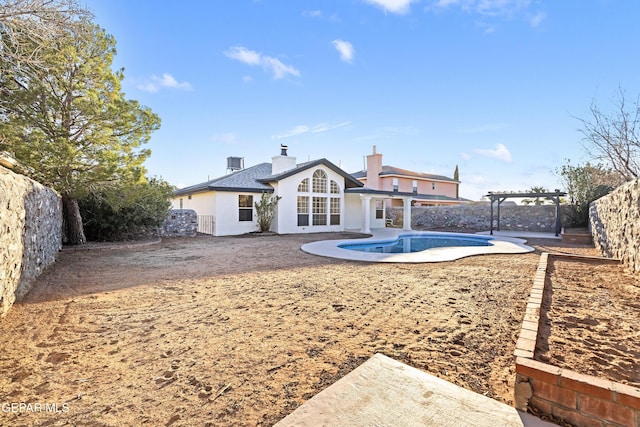 back of house featuring a fenced in pool, a pergola, and a patio area