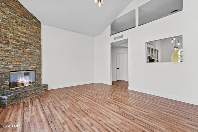 unfurnished living room with hardwood / wood-style floors, a fireplace, and high vaulted ceiling