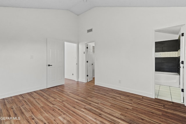 unfurnished room with lofted ceiling and wood-type flooring