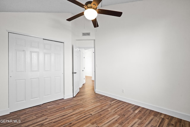 unfurnished bedroom featuring wood-type flooring, vaulted ceiling, ceiling fan, and a closet