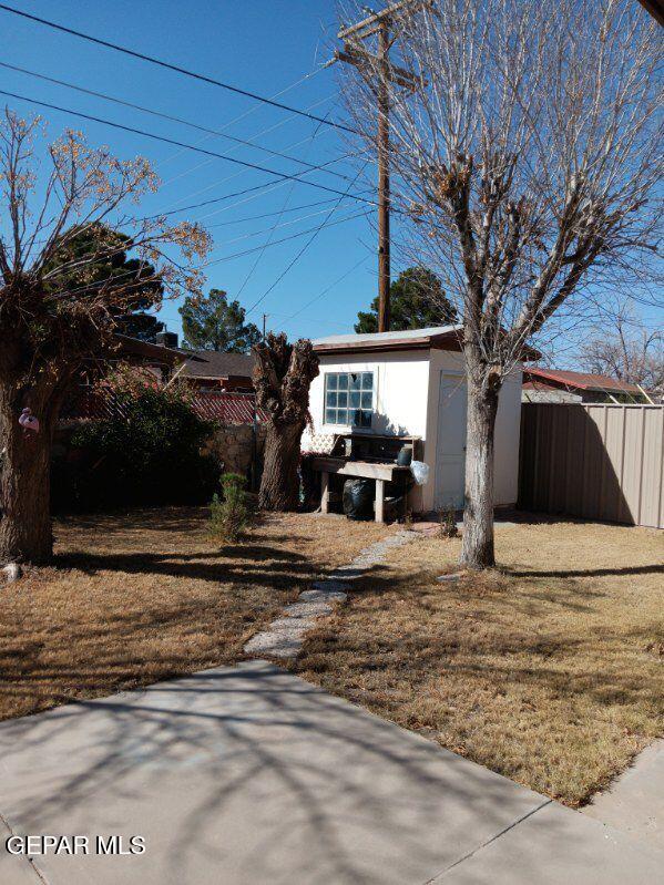 view of front facade featuring a shed and a front yard