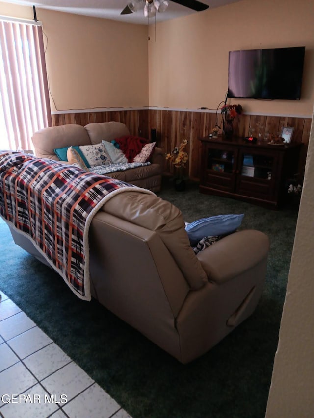 bedroom featuring ceiling fan, light tile patterned floors, and wood walls