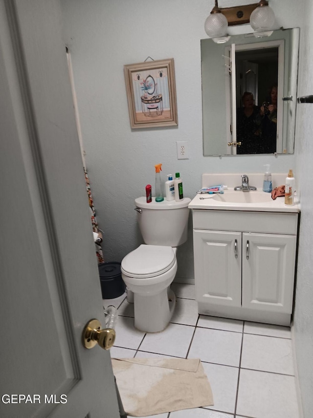 bathroom featuring vanity, tile patterned floors, and toilet