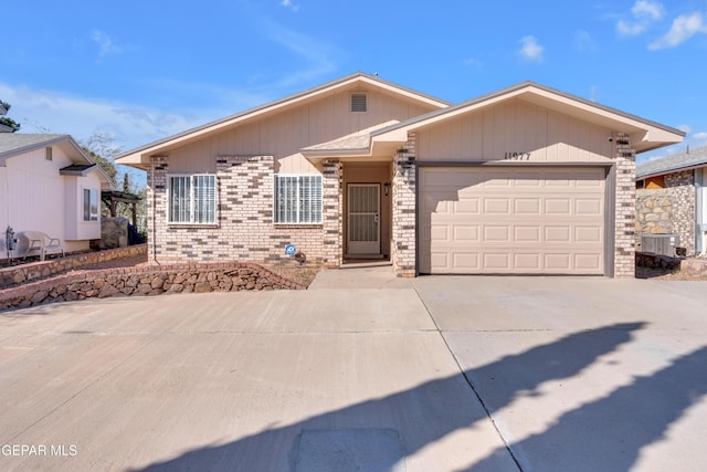 view of front of home with a garage and central AC