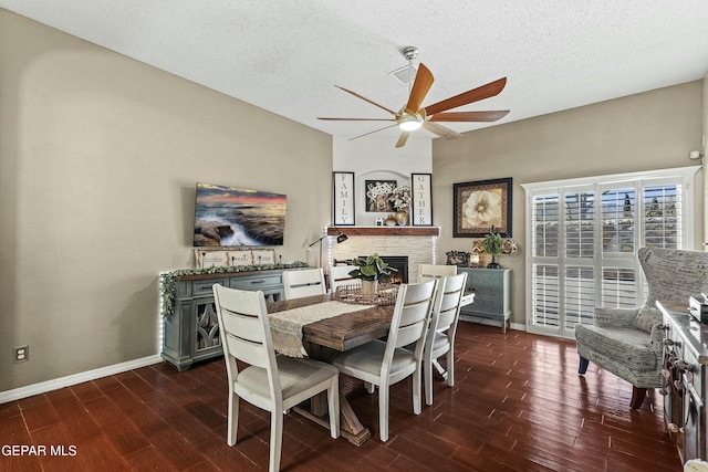 dining room featuring ceiling fan, dark hardwood / wood-style floors, and a textured ceiling