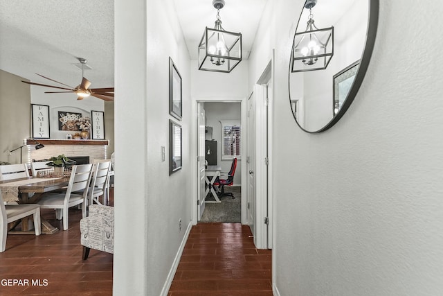 hall featuring dark hardwood / wood-style flooring, a chandelier, and a textured ceiling