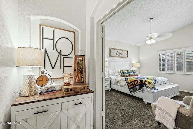 bedroom featuring a textured ceiling and dark carpet