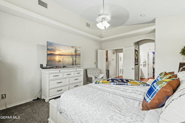 carpeted bedroom featuring ceiling fan and a tray ceiling