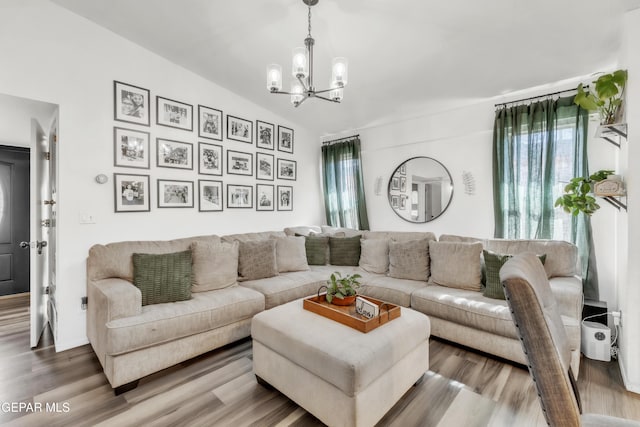 living room featuring wood-type flooring and an inviting chandelier