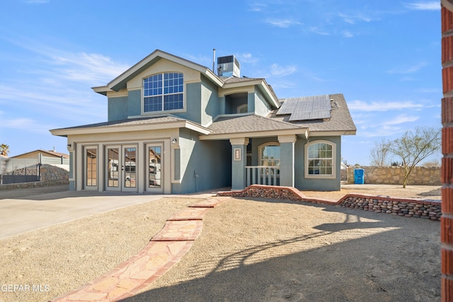 view of front of property with central AC unit and solar panels