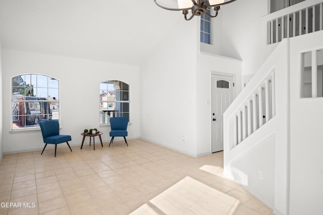 entrance foyer featuring a towering ceiling, a chandelier, and light tile patterned floors