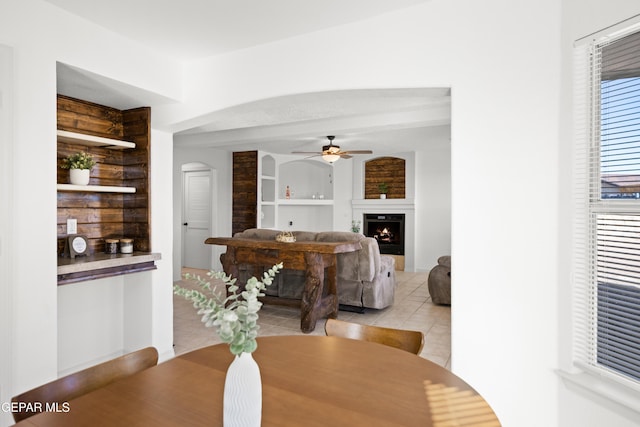 tiled dining space with built in features and ceiling fan