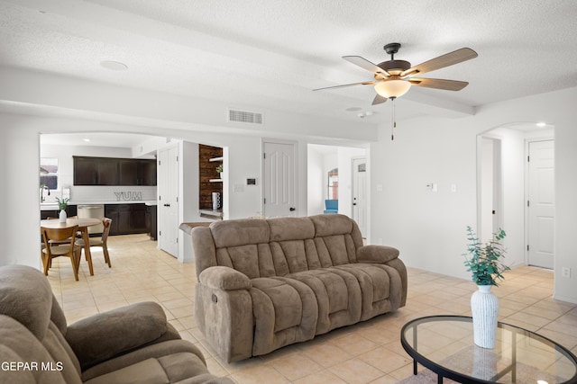 tiled living room featuring ceiling fan and a textured ceiling