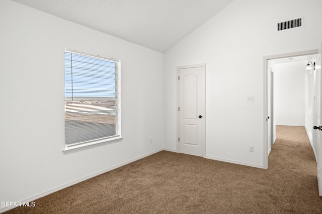 unfurnished bedroom with lofted ceiling and carpet