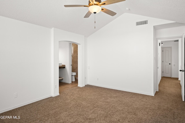 interior space featuring vaulted ceiling, carpet, ceiling fan, and a textured ceiling