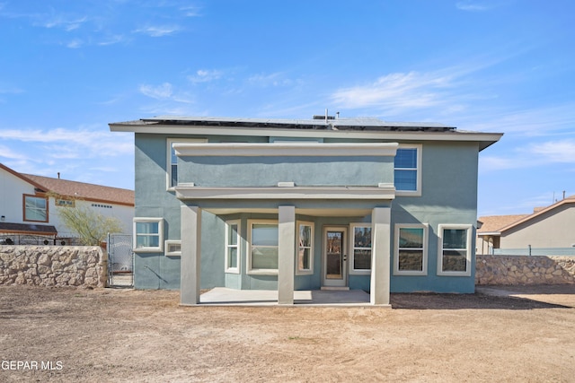 rear view of house with a patio area and solar panels