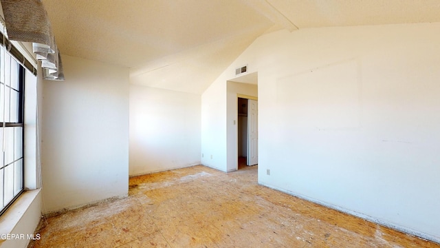 unfurnished room featuring vaulted ceiling