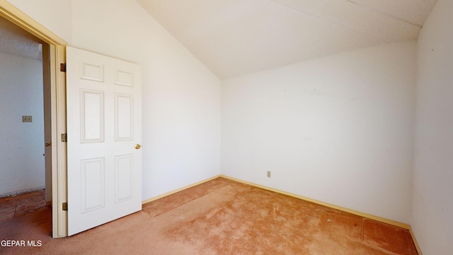 empty room featuring lofted ceiling and carpet flooring