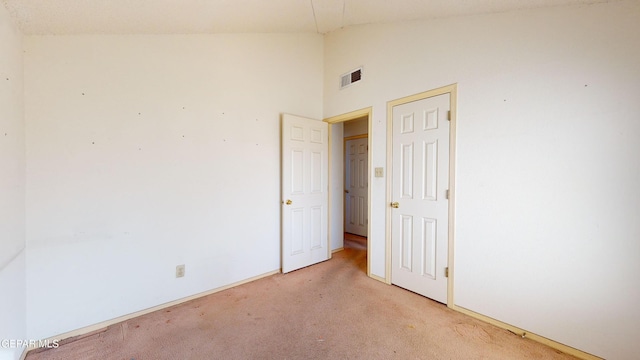 spare room featuring high vaulted ceiling and light carpet