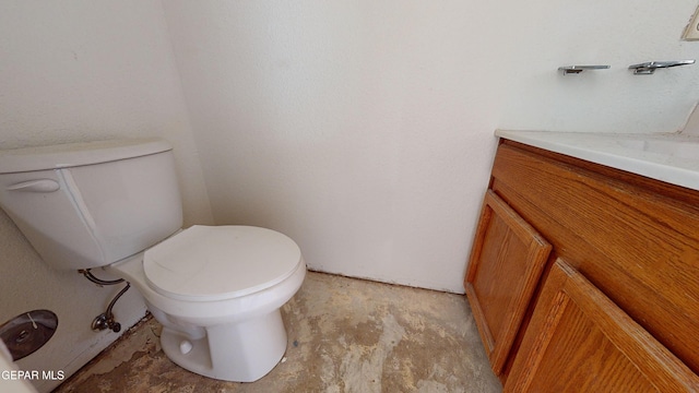 bathroom with vanity, toilet, and concrete flooring