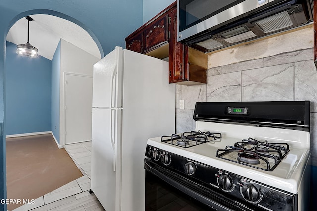 kitchen featuring white refrigerator, range with gas cooktop, and light tile patterned floors