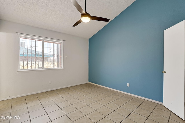 empty room featuring ceiling fan, vaulted ceiling, and a textured ceiling