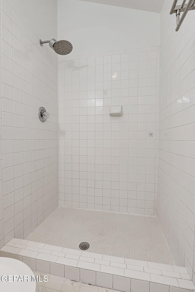 bathroom featuring toilet and a tile shower