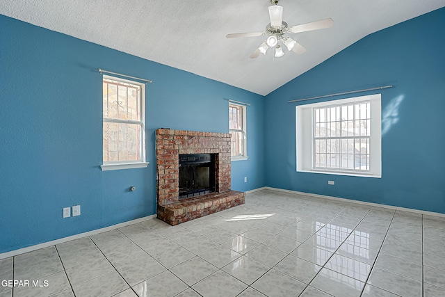 unfurnished living room featuring ceiling fan, lofted ceiling, a brick fireplace, and a wealth of natural light